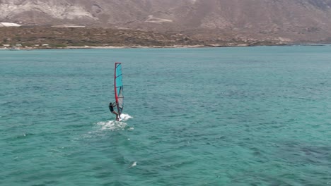 Person-windsurfing-near-coastline-of-Crete-island,-Greece