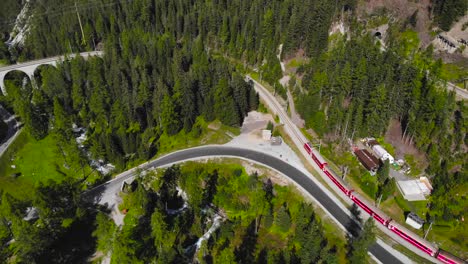 Aerial:-red-train-in-mountainous-landscape