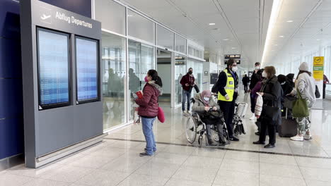 Passagiere-Am-Flughafen-München-Lesen-Fluginformationsanzeigesystem