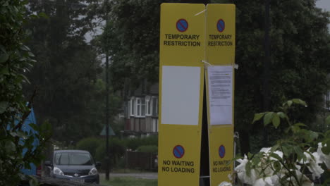 Yellow-Temporary-Restricting-No-Parking-Signs-On-Lamppost-On-Road-In-Harrow,-London