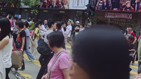 Different-ages-of-Chinese-people-walking-through-crosswalk-in-Causeway-Bay-leisure-area
