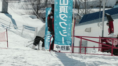 Skiing---Male-Skier-Slowing-Down-On-Hill-Towards-Exit-Of-Ski-Resort-In-Okuhida-Hirayu,-Gifu,-Japan