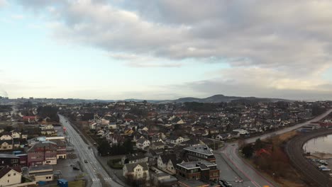 Lura-and-road-Stavangerveien-close-to-E39-in-Sandnes-Norway---Ascending-aerial-from-gas-and-charging-station-in-Lurevika-looking-in-direction-of-Forus---Norway