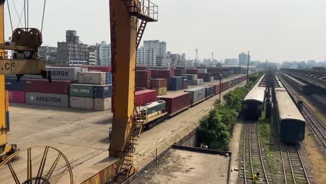 warehouse-where-a-truck-is-bringing-a-container-to-be-loaded-on-the-goods-train-and-a-railway-station-in-Komlapur,-Bangladesh---Pan-view-from-left-to-right