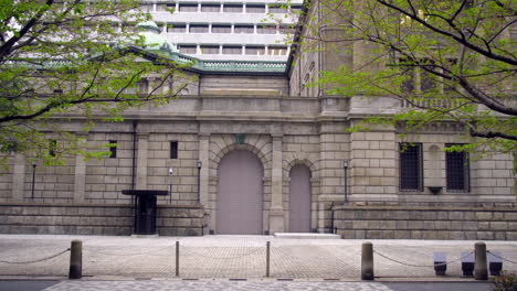 TOKYO,-JAPAN,-circa-April-2020:-people-bike-riding-in-front-of-protected-building,-Bank-of-Japan,-at-old-downtown-in-central-financial-district,-spring-day