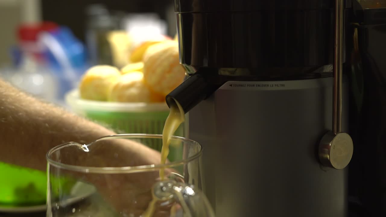 Premium stock video Close up of person using electric juicer with