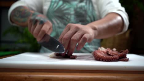 Latin-cooker-chef-chopping-octopus-tentacles-in-slow-motion