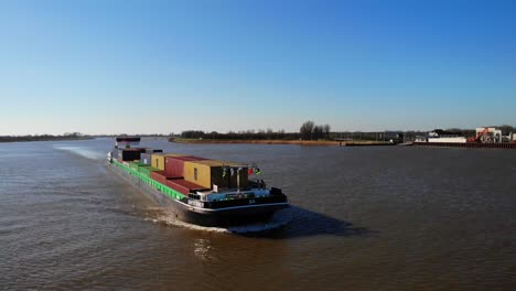 Aerial-Forward-Bow-View-Of-Sendo-Liner-Inland-Freighter-Along-Der-Lek-In-Groot-Ammers