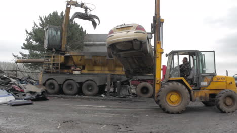 Fork-lift-truch-drops-car-on-scrap-heap-ready-to-be-crushed