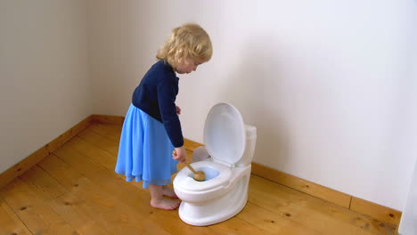 A-child-cleaning-a-potty-toilet-with-detergent-and-a-brush
