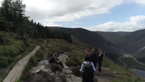 Luftaufnahmen-Folgen-Menschen-Beim-Wandern-In-Der-Wunderschönen-Glendalough-Upper-Lake-Szene,-Irland