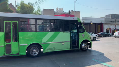 Autobús-La-Buseta-De-Color-Verde-Que-Viaja-A-Lo-Largo-De-Una-Carretera-Muy-Transitada-En-La-Ciudad-De-México