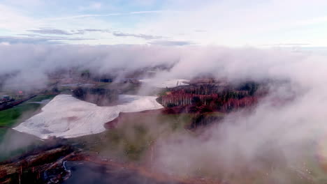 Mysterious-drone-flight-through-clouds-over-farmland-with-melting-snow
