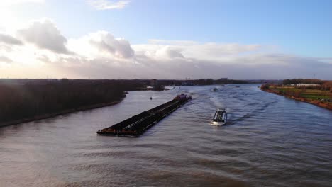 Aerial-View-Of-Barge-Containers-Being-Move-Along-By-Daan-Push-Tow-Ship-Along-Oude-Maas