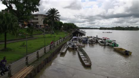 Several-river-boats-docked-along-the-shore-of-a-large-river-in-tropical-climate