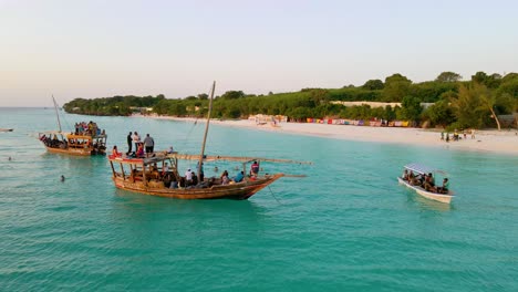 Nungwi-Beach,-Zanzibar---Tanzania---June-18,-2022---fishing-Boats-with-tourists-on-the-Indian-ocean-during-sunset