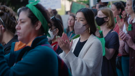 Women-with-green-bandanas-clap-and-hold-signs-in-a-crowd-of-pro-choice-protesters-at-an-abortion-rights-rally-in-Downtown