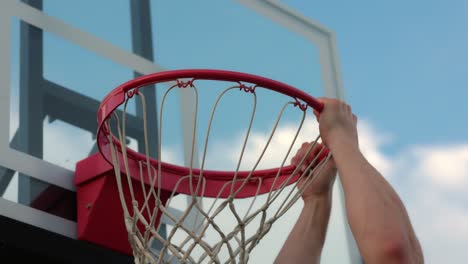 Ein-Mann-Taucht-Auf-Ein-Neues-Basketballnetz-Und-Hält-Sich-Nach-Dem-Einwurf-Am-Rand-Des-Balls-Fest