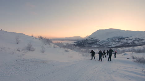 Grupo-De-Personas-Subiendo-Una-Colina-Con-Esquís-De-Fondo-Y-Raquetas-De-Nieve-En-El-Norte-De-Suecia
