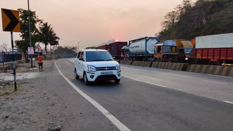 Indian-Car-driver-breaking-traffic-rules,-driving-on-wrong-way-on-Road-heavy-traffic-on-one-side-on-Indian-Highway-road-with-big-trucks,containers,big-vehicles-with-goods