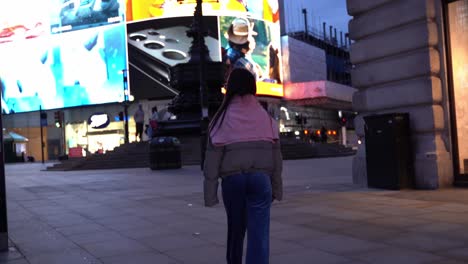 Following-a-beautiful-young-woman-in-Piccadilly-Circus,-wide-shot