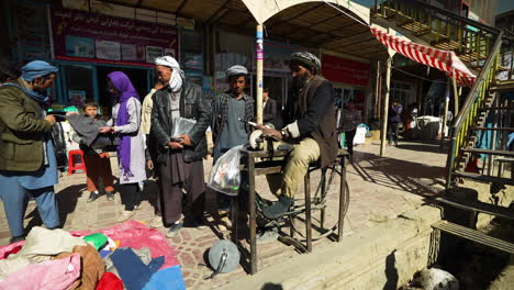 Local-Guy-Sharpening-Knives-On-The-Street-The-Old-Way-In-Bamyan,-Afghanistan---static,-medium-shot