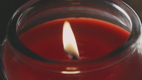 Shimmering-Flame-Of-Lit-Red-Candle-In-A-Glass-Holder
