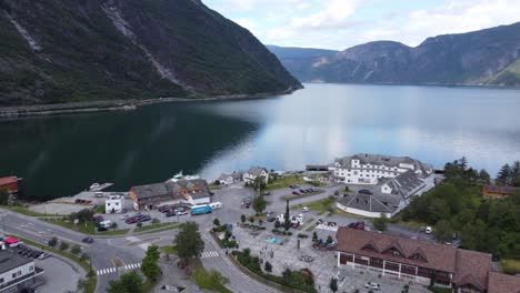 Beautiful-Eidfjord-town-center---Rotating-aerial-during-summer-morning---Showing-buildings-with-road-and-fjord---Norway