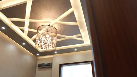 Looking-Up-At-Hanging-Lighting-Fixture-And-Light-Ceiling-Panels