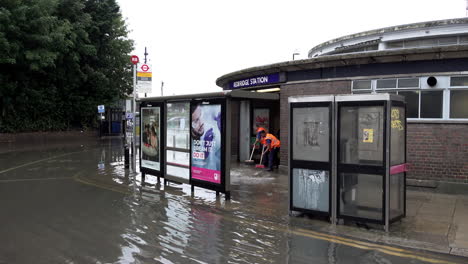 Transport-for-London-staff-brush-floodwater-away-from-Redbridge-Underground-station-entrance-after-thunderstorms-that-saw-a-month’s-worth-of-torrential-rain-fall-in-several-hours-across-the-capital