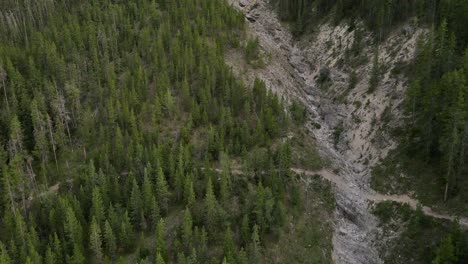 Fast-Push-In-movement-by-4k-drone-towards-magnificent-mountain-in-Kananaskis-Country-revealing-a-hiker-making-his-way-down-the-steep-rocky-hill