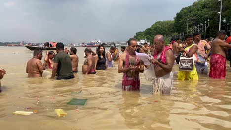Gruppe-Von-Menschen,-Die-Am-Letzten-Tag-Von-Pitru-Paksha-Ihr-Obligatorisches-Ritual-Durchführen,-Ihren-Pitras-Wasser-Anzubieten