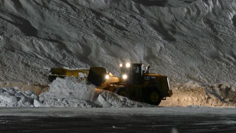 Yellow-Excavator-with-a-snow-plow-cleans-and-pushes-the-snow-onto-a-huge-pile-,-static