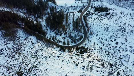 Car-driving-on-frozen-mountain-road-in-winter-season,-Tatry-landscape