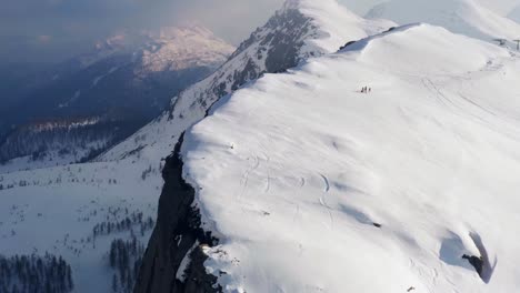 Filmische-Luftaufnahme-Von-Vier-Wanderern,-Die-Den-Passo-Rolle-Oder-Den-Rollpass-Mit-Schnee-Erklimmen