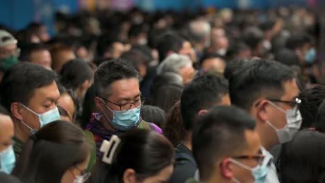 Man-Sieht-Pendler-Mit-Gesichtsmasken-Während-Der-Hauptverkehrszeit-Darauf-Warten,-Dass-Ein-U-Bahn-Zug-An-Einer-MTR-Station-In-Hongkong-Ankommt