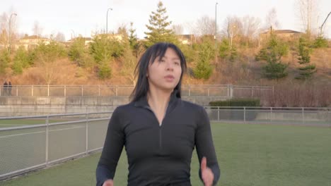 Young-Asian-athlete-high-knees-with-arms-exercise-Medium-shot