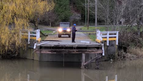 A-government-safety-inspector-standing-at-the-end-of-a-bridge-that-has-been-completely-washed-away-and-destroyed-by-the-floods-in-Abbotsford,-the-man-taking-notes-and-assessing-the-damage-in-a-report