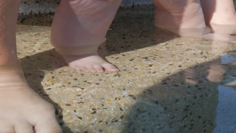 Füße-Einer-Mutter-Und-Ihres-Babys-Im-Klaren-Poolwasser-Im-Sommer