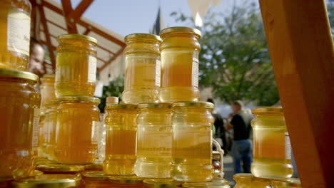 FAST-TILT-UP-many-jars-of-honey-at-the-market-backlit-by-the-sun