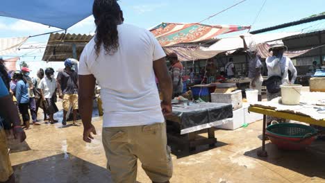 Walking-through-the-local-outdoor-fish-market-with-lots-of-stands-and-vendors-in-Negombo,-Sri-Lanka