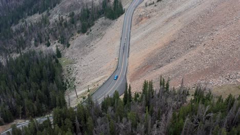 Aerial,-car-driving-on-American-national-park-road-on-cliff-side