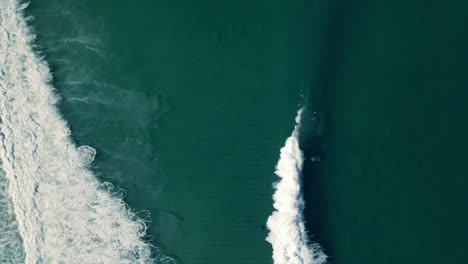 Surfers-duck-dive-waves-drone-view
