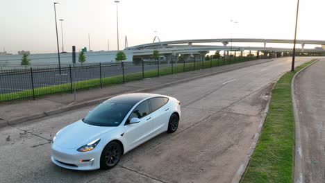 Weißer-Tesla-Model-3-Mit-Eingeschalteten-Scheinwerfern-Und-Blinker