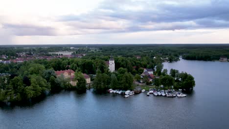 Aerial-drone-timelapse-of-Johanniterkirche-church-next-to-a-beautiful-lake