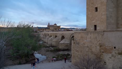 People-enjoying-evening-stroll-in-Cordoba,-Spain-with-Mezquita-in-background