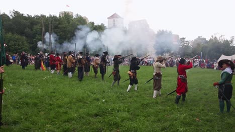 Group-of-infantry-soldiers-firing-muskets-during-battle-reenactment-in-Tenczyn-Castle,-Poland