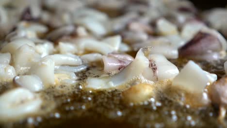 bokeh-of-chopped-squid-fried-in-oil-during-the-preparation-of-a-Spanish-fideua