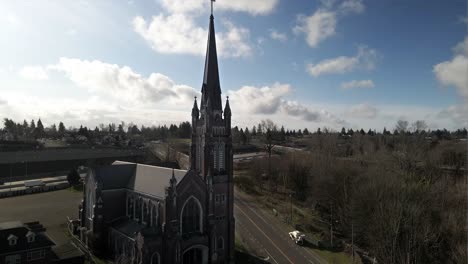 Rising-up-revealing-the-steeple-and-cross-of-Holy-Rosary-Catholic-Church,-Tacoma-WA,-aerial