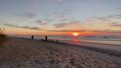Tourist-On-Sandy-Shoreline-With-Beautiful-Sunset-Sky-Over-Seascape